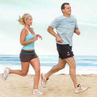 Muž a žena běhající po pláži