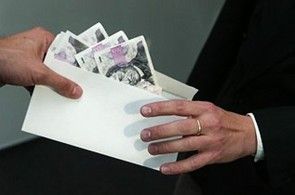 Ruce předávající si obálku s penězi